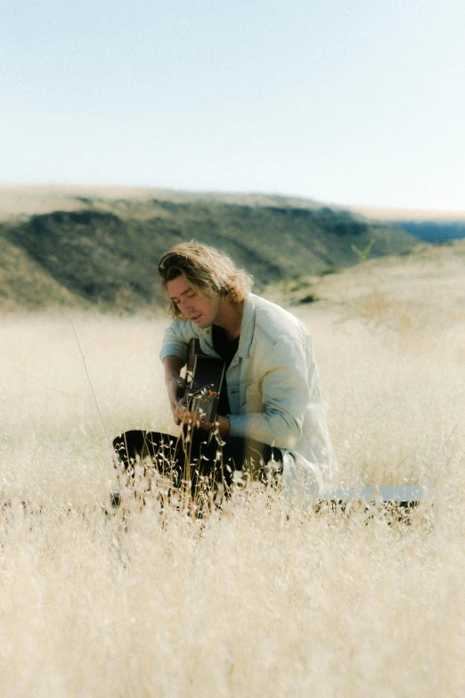 a man kneeling in the middle of a field