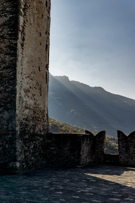 some kind of stone wall with the mountains behind it