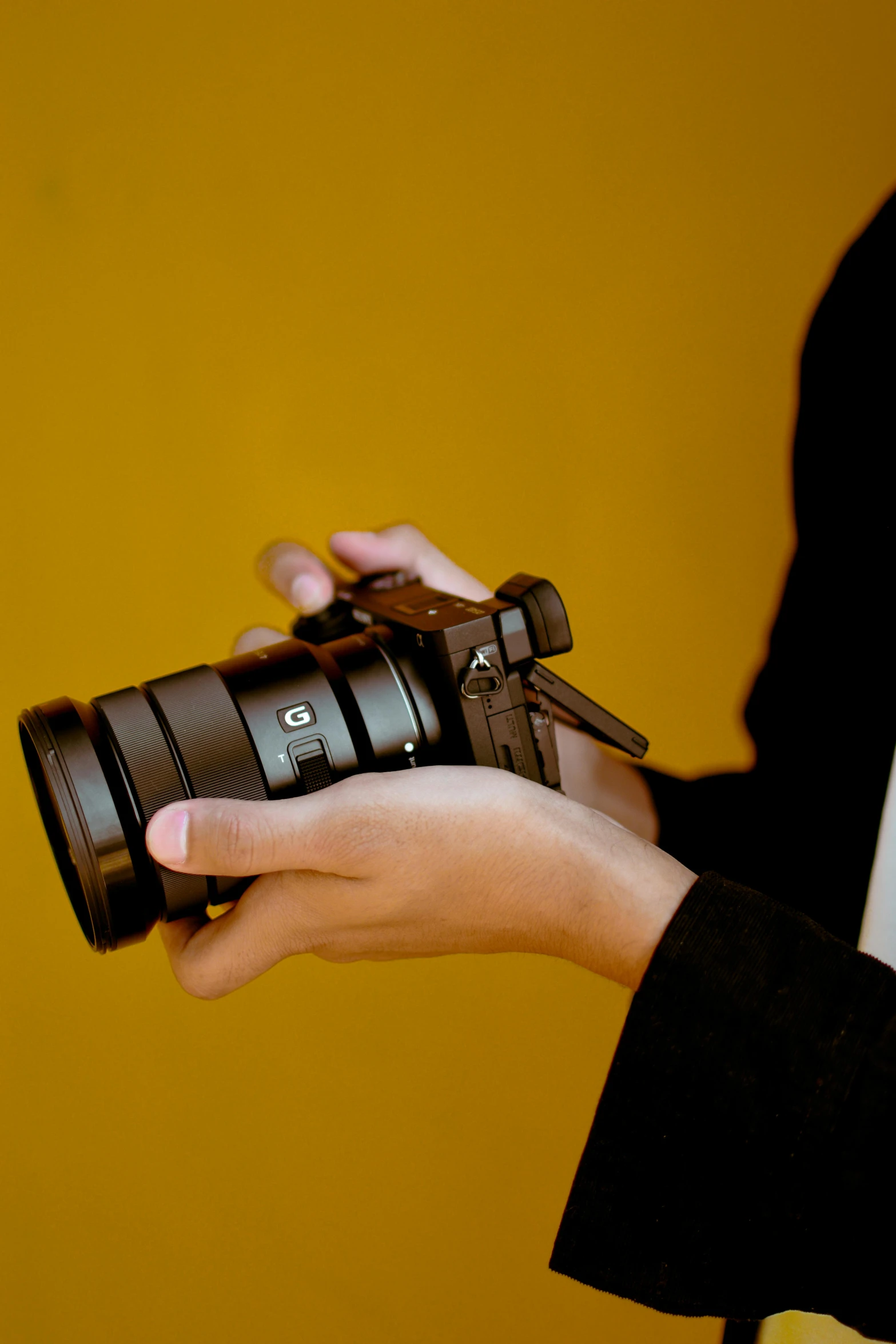 the hands holding a camera are shown close together