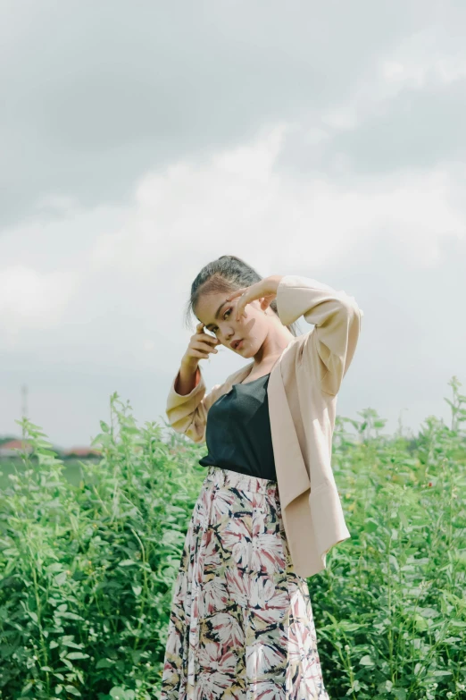 a woman in floral dress standing outside in tall grass