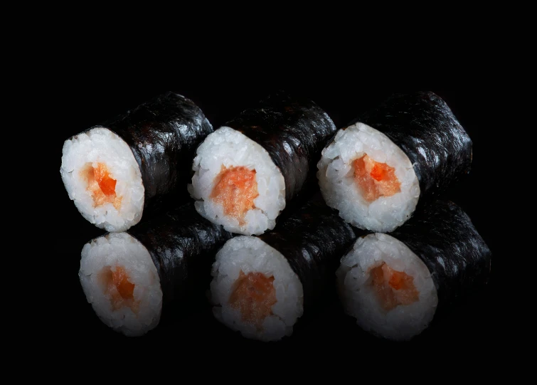 there are three pieces of sushi that are black and red
