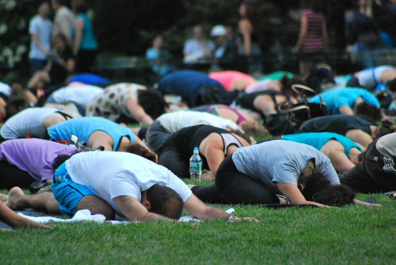 people are laying on the grass during a ceremony