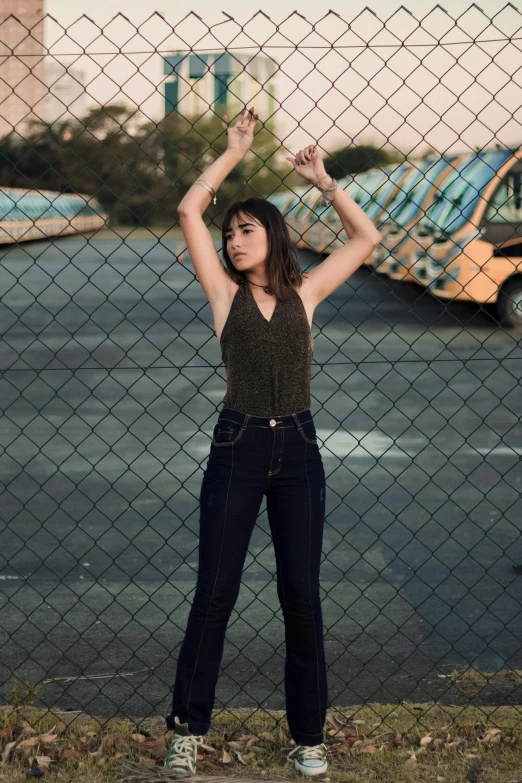 a girl leaning on a fence near a car