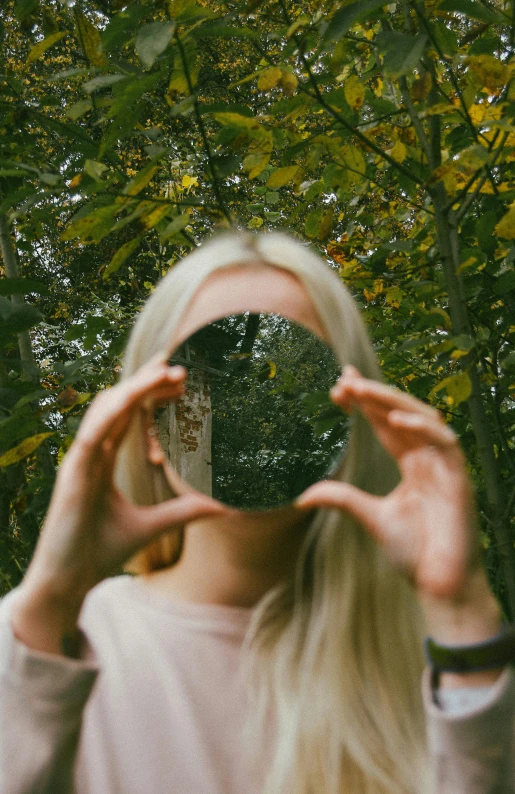 a woman holding a black glass and covering her eyes