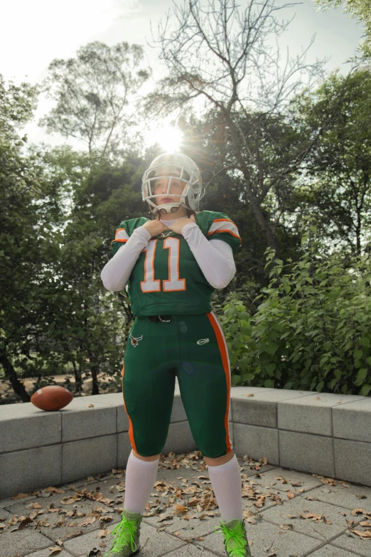 a football player in a green uniform is posing for a picture