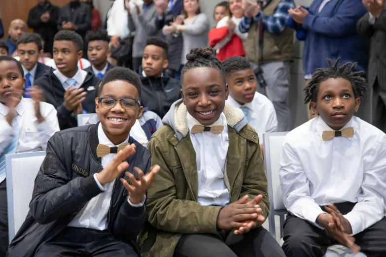 several children wearing bow ties posing for a po