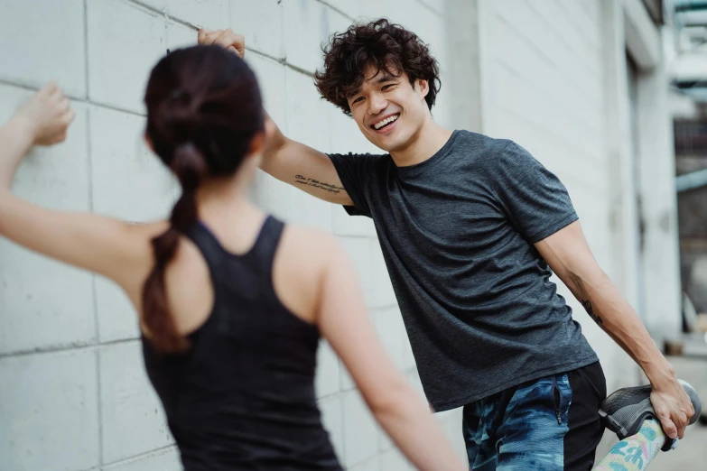 a man with his skateboard standing next to a woman