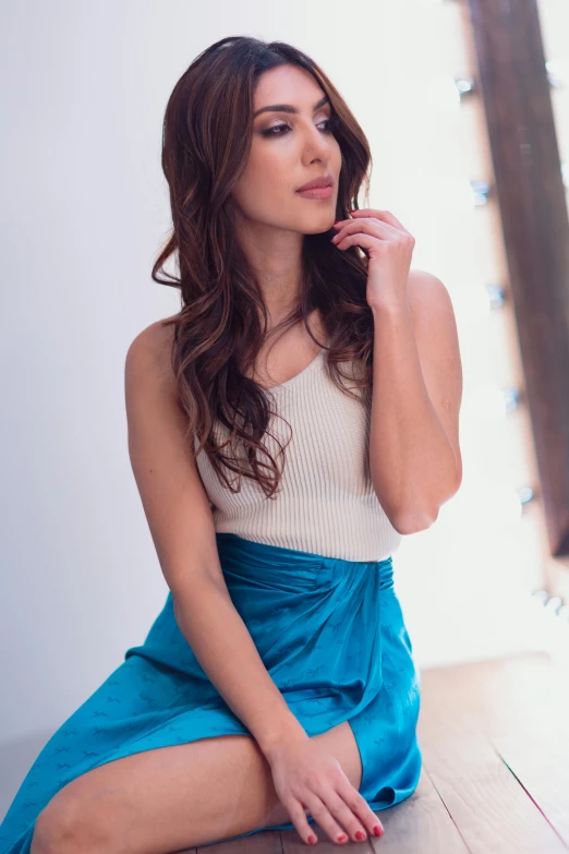 young woman sitting on the floor wearing a skirt