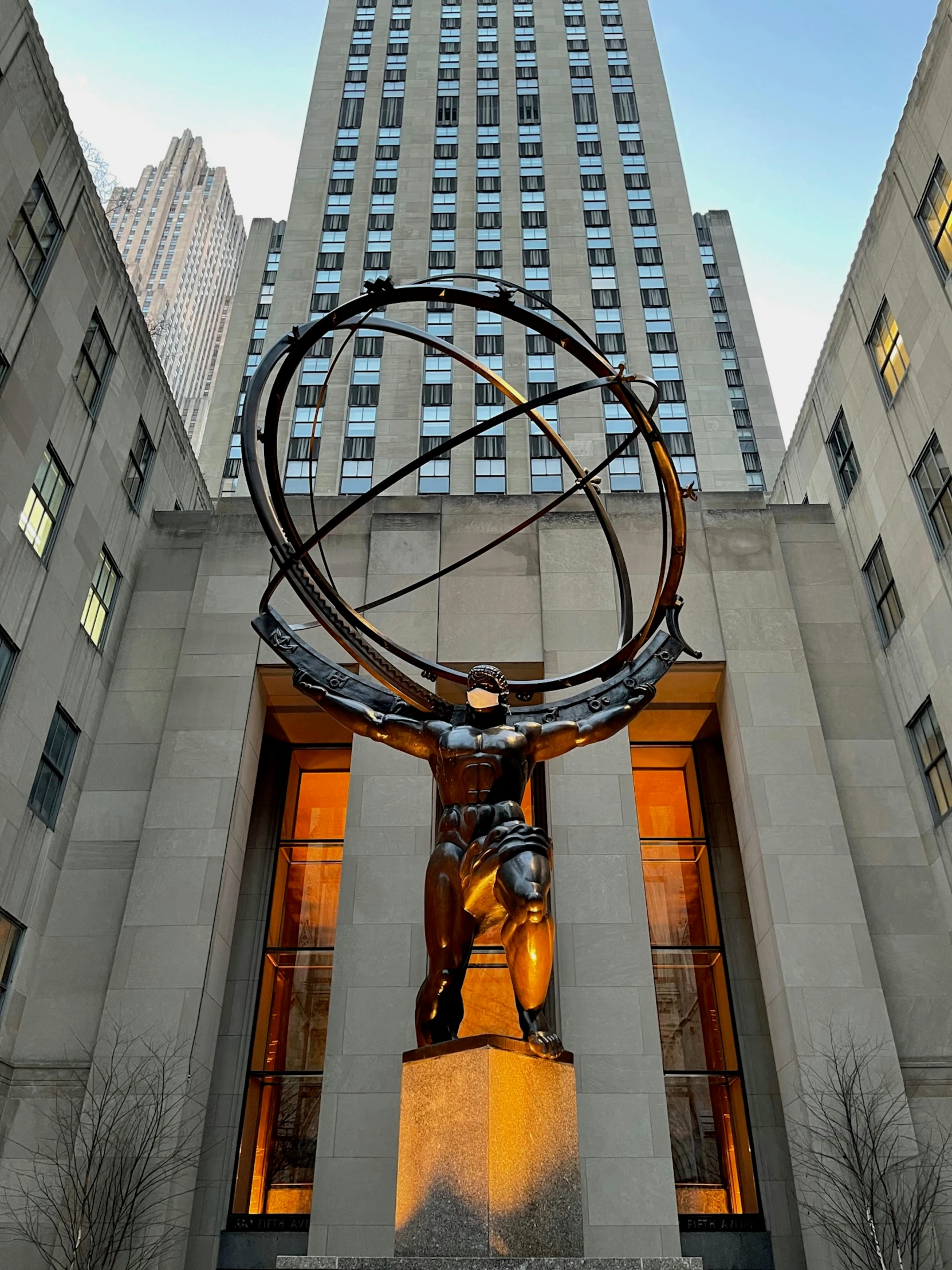 a statue in front of two tall buildings at night