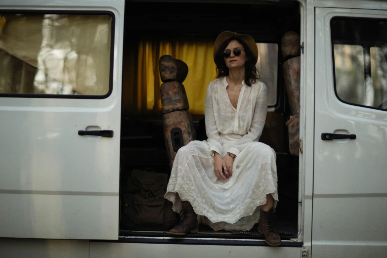 an attractive lady sits in a van with the doors open