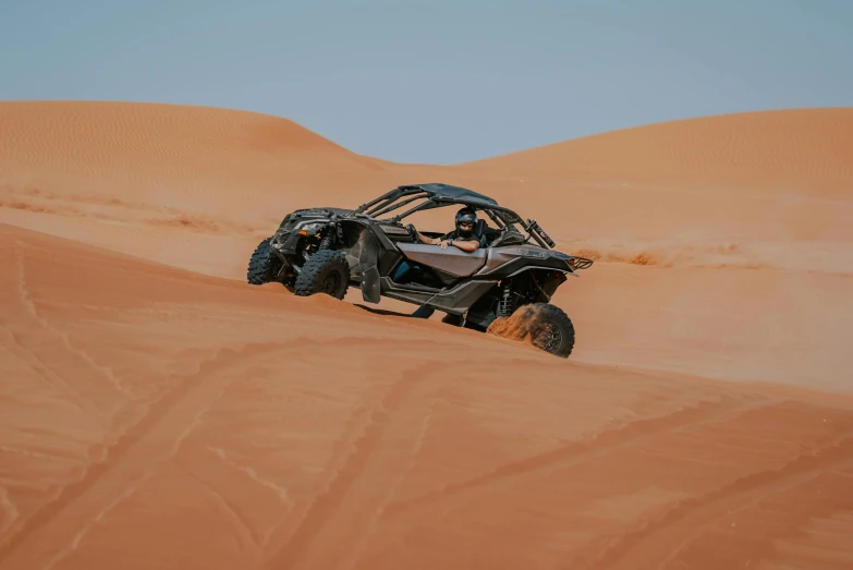 a car in the sand driving around a bend