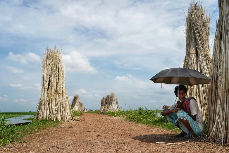 a person kneeling down holding an umbrella