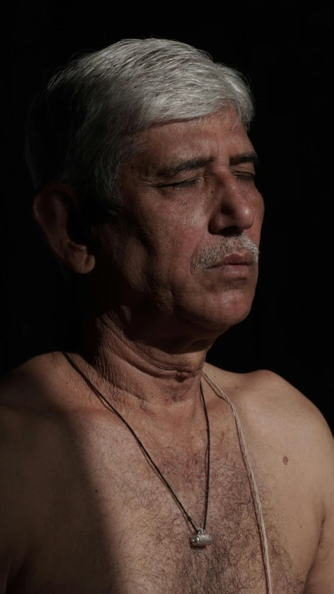 older man with white shirt and moustache posing for the camera