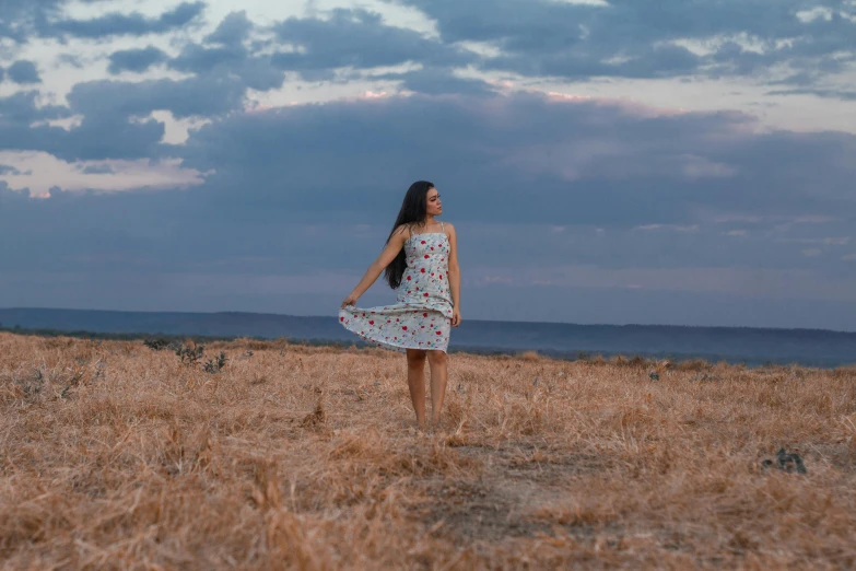 a woman in a field looking down at the sky