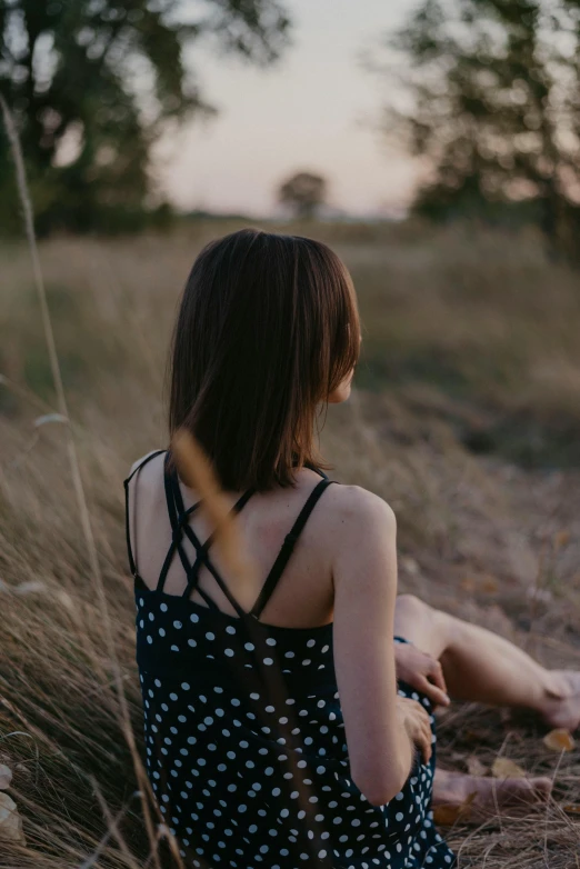 the back of a woman sitting in tall grass