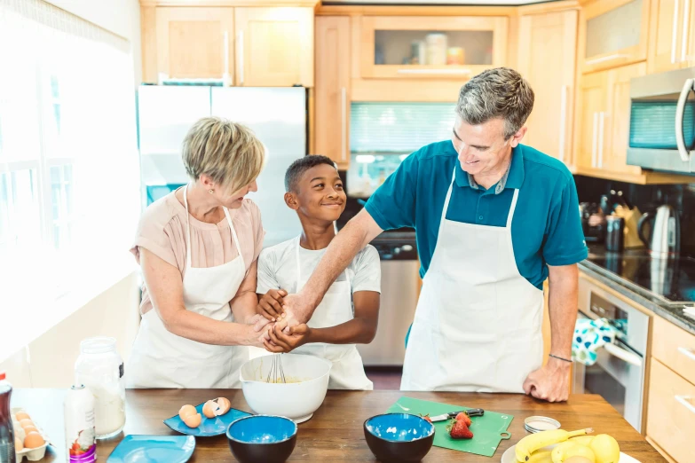 a woman and two boys cooking together in the kitchen