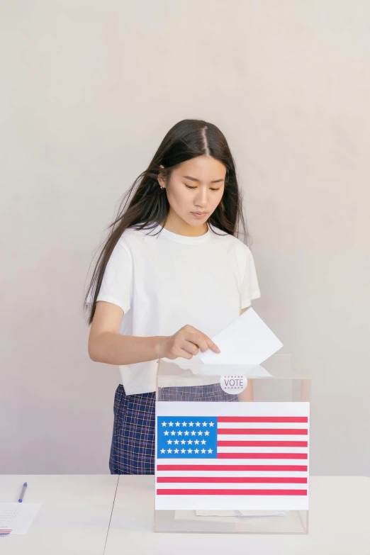 a woman putting a voting card into a box