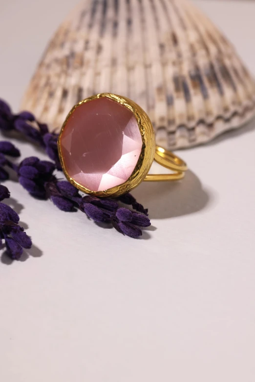 a close up of a ring on a table near a shell