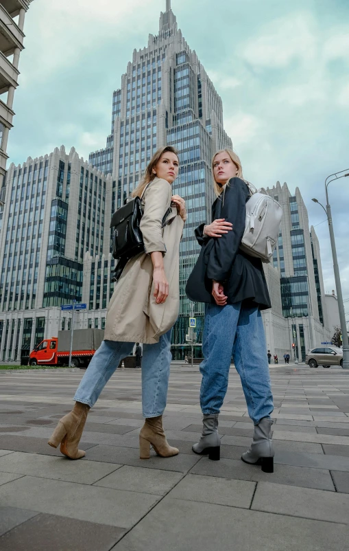 two women are standing near each other and one has on boots