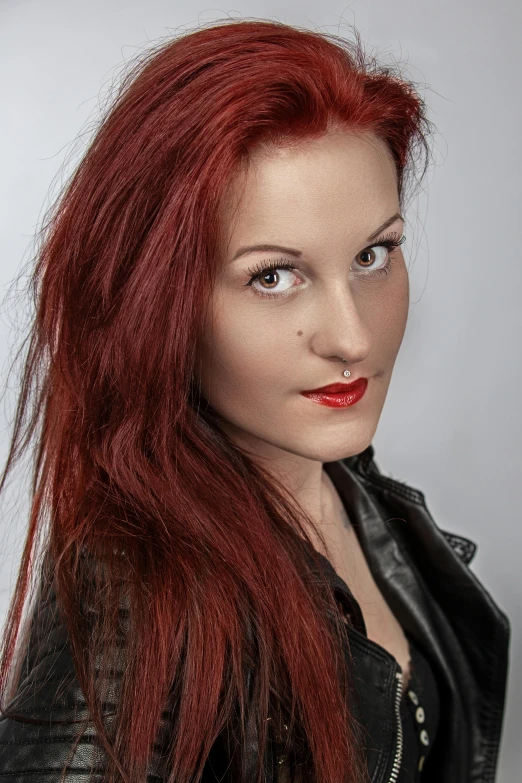 a woman wearing red hair and black jacket with red lipstick on her lips