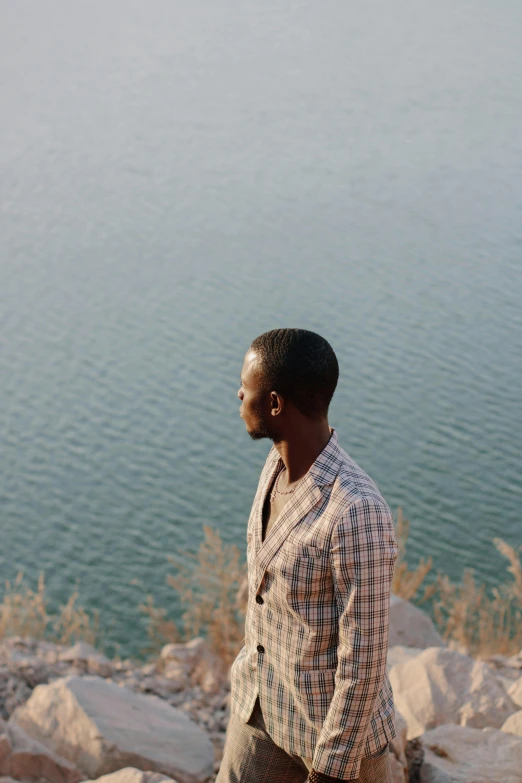 man in checked shirt looking away at a lake