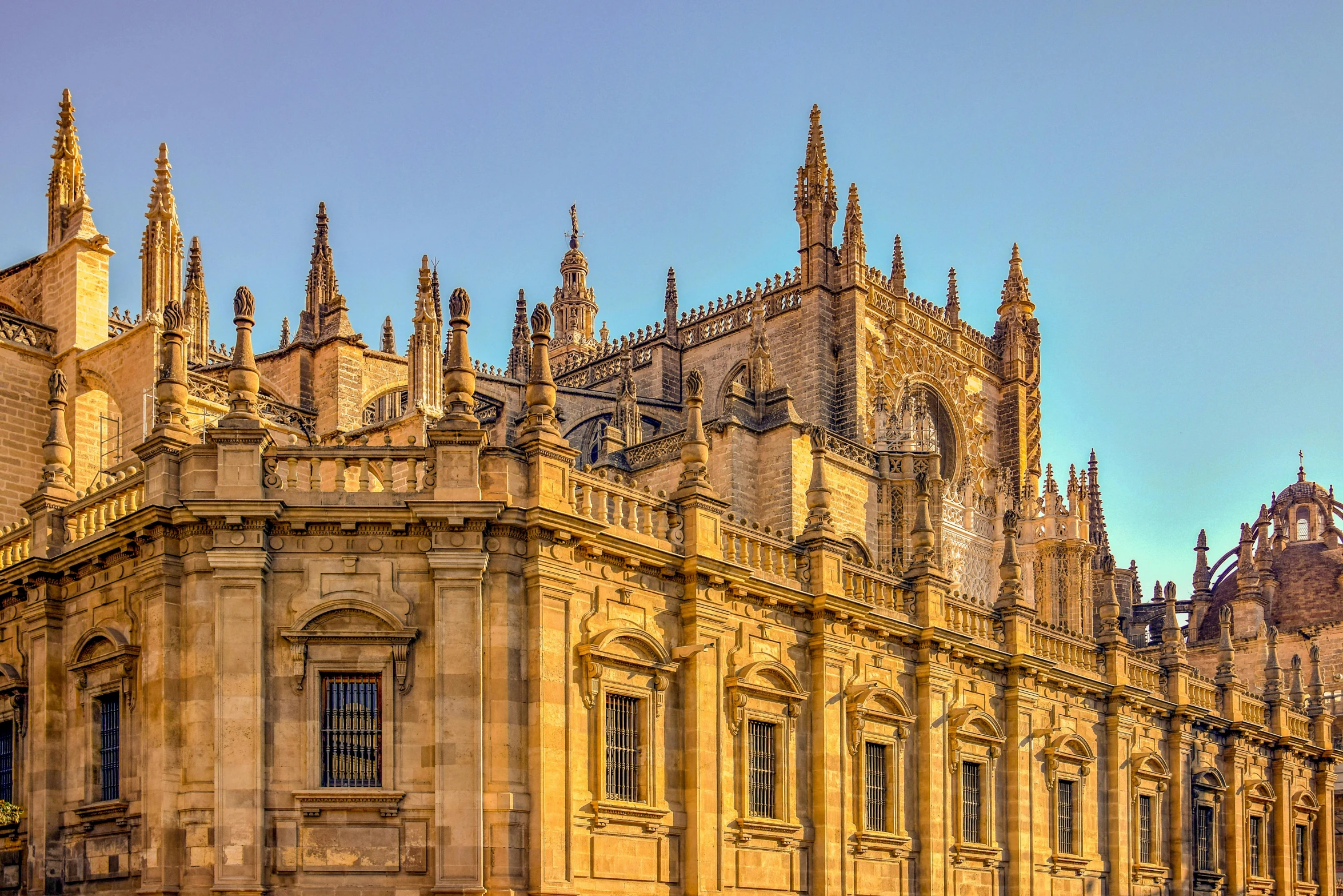 the sun sets in front of an old church building