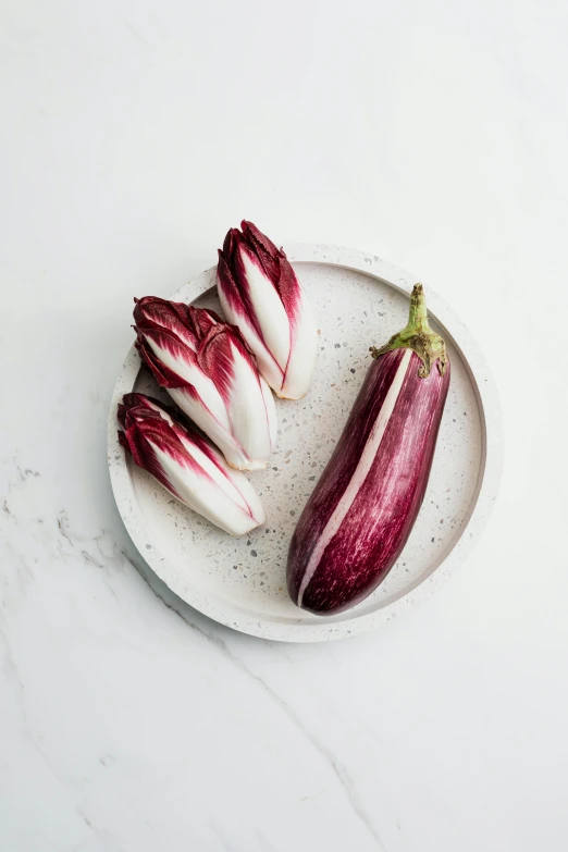 purple striped vegetables are arranged on a plate