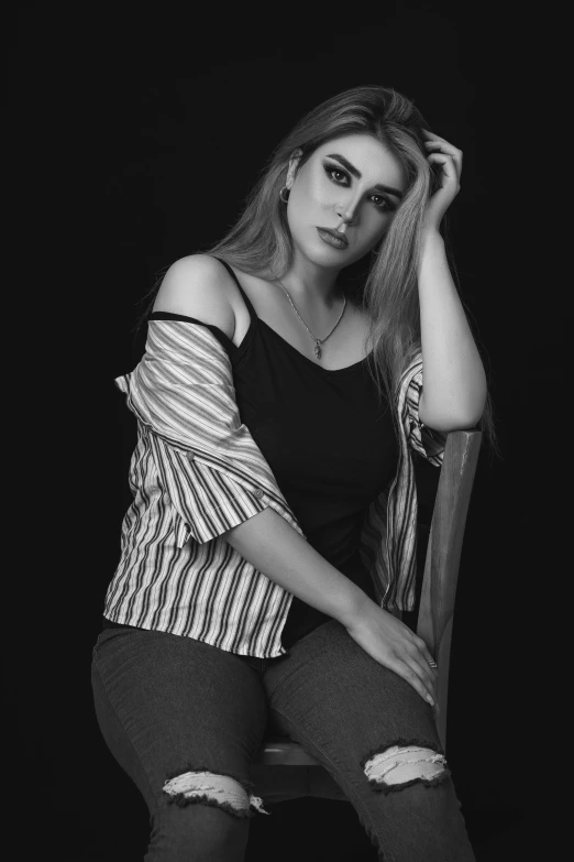 black and white image of a woman sitting on a chair