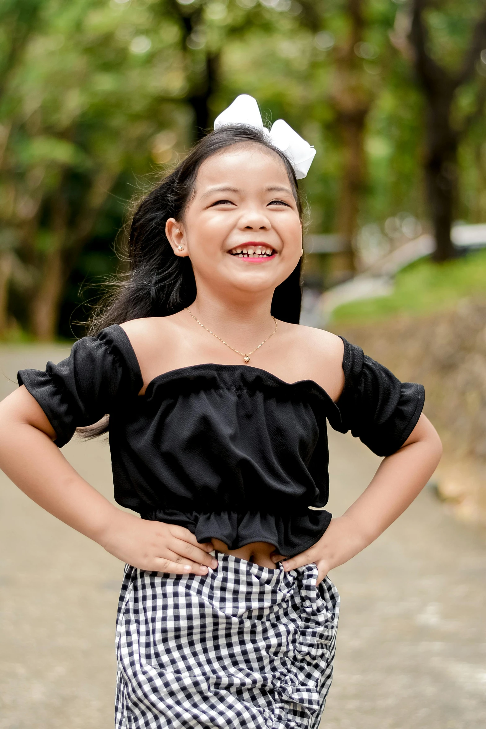 a girl posing with her hand on the back of her waist