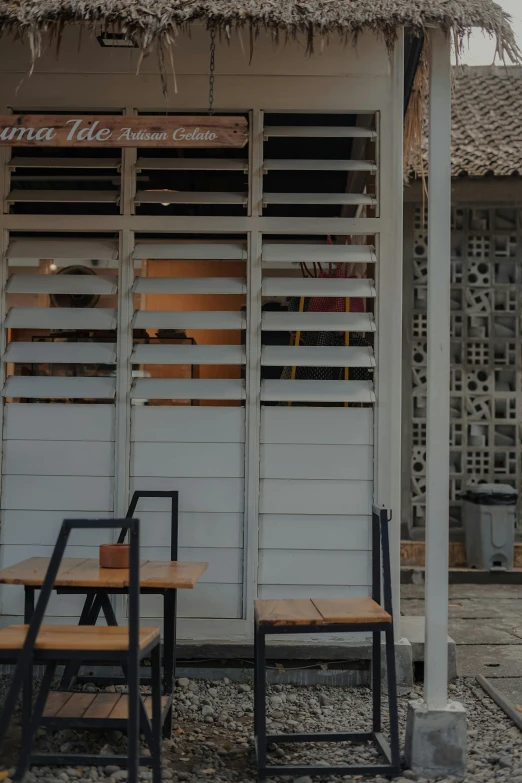 there are two small tables and chairs outside a restaurant