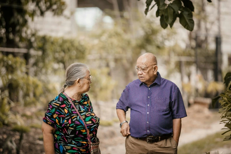 a couple stand under a tree and talk