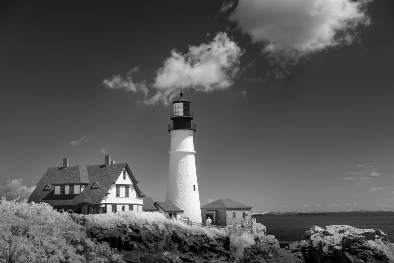 a light house on a cliff with clouds in the sky