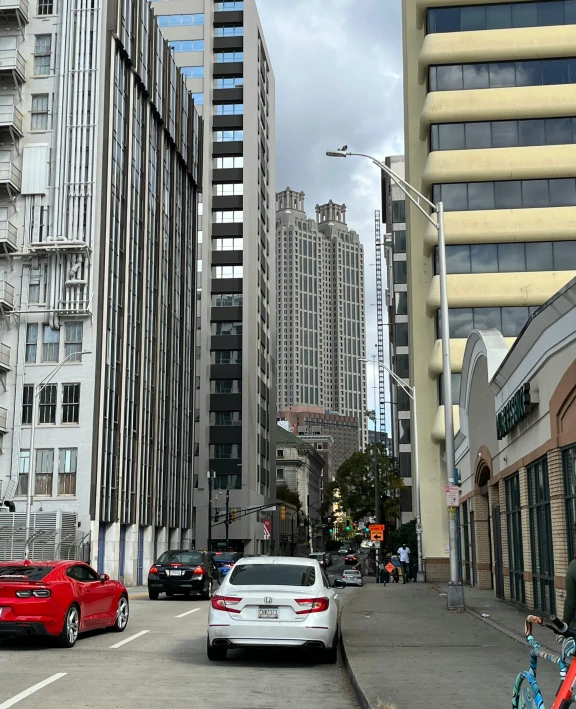 several vehicles parked on a city street with buildings in the background