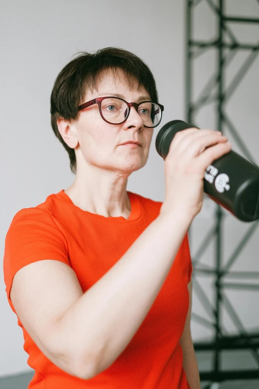 a woman with a microphone and glasses on a stage