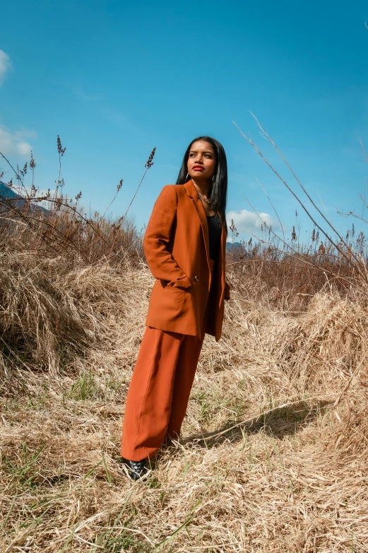 a young woman poses in a tall grass field