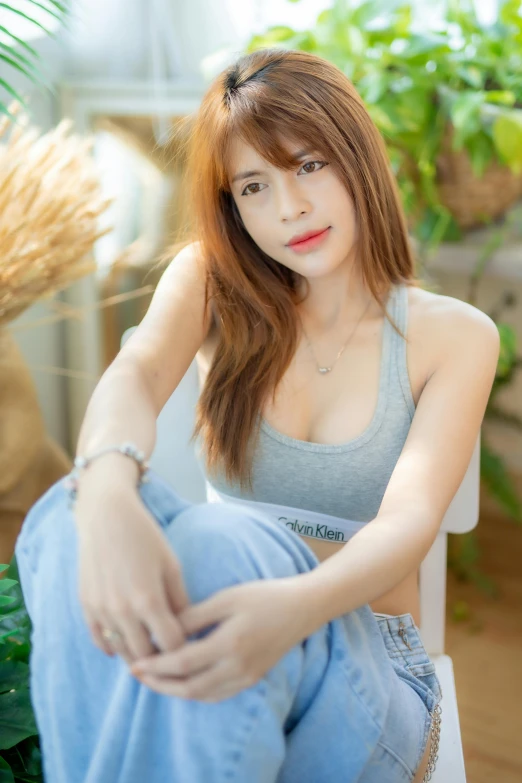 a very attractive young lady sitting on a white chair