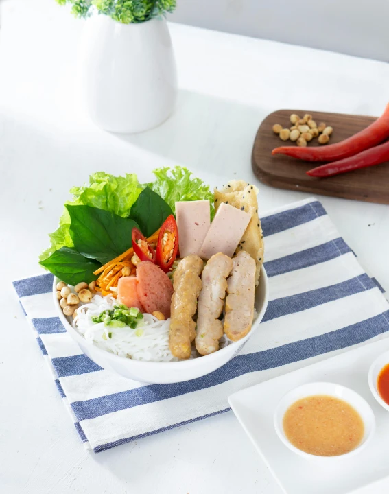 a plate with meats and vegetables next to sauce