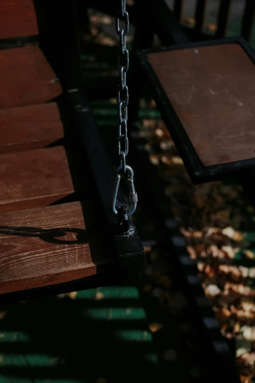 a view of an old bench with chain hanging on it