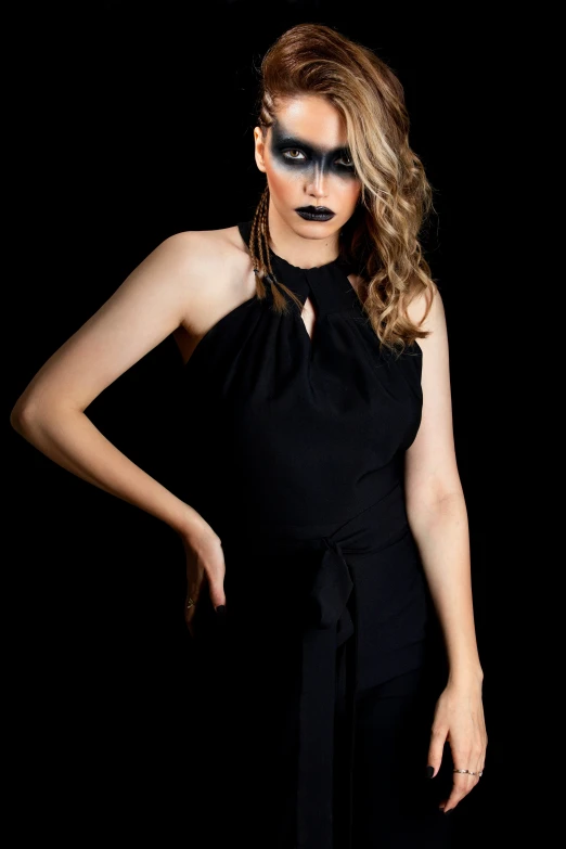 the model in a black outfit is dressed up with makeup