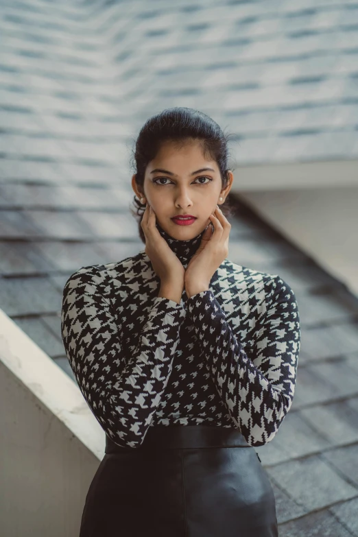 the woman is posing on the stairs and leaning her head on her chin