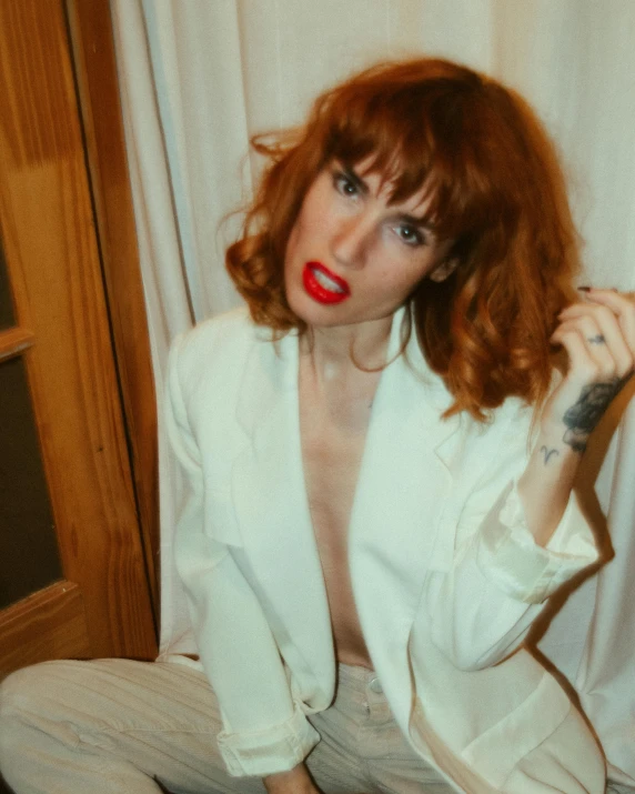 a woman in red lipstick sitting down