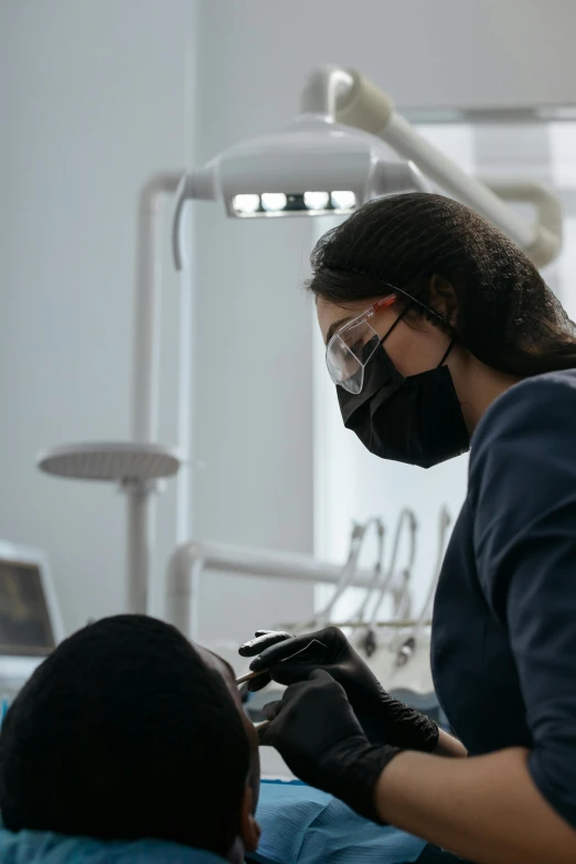 a dental assistant is attending to a patient in the dentist's office