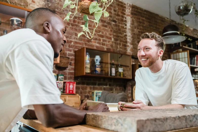 two men sit at a counter in a cafe