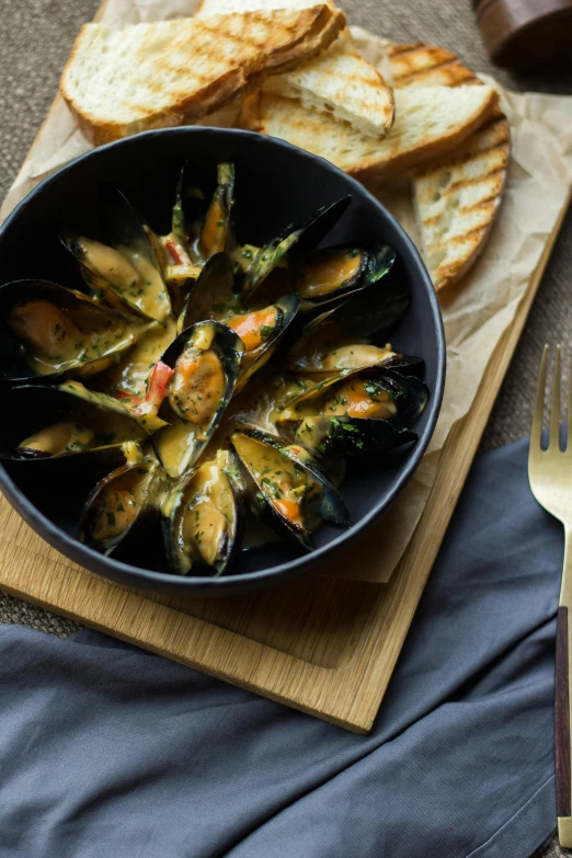 steamed mussels in pan and bread on  board