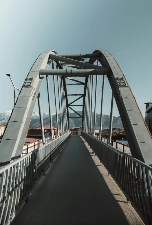 a large long metal bridge crossing a river