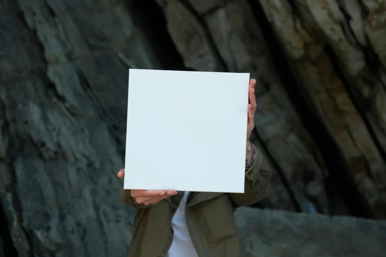 a man holding up a paper in front of his face