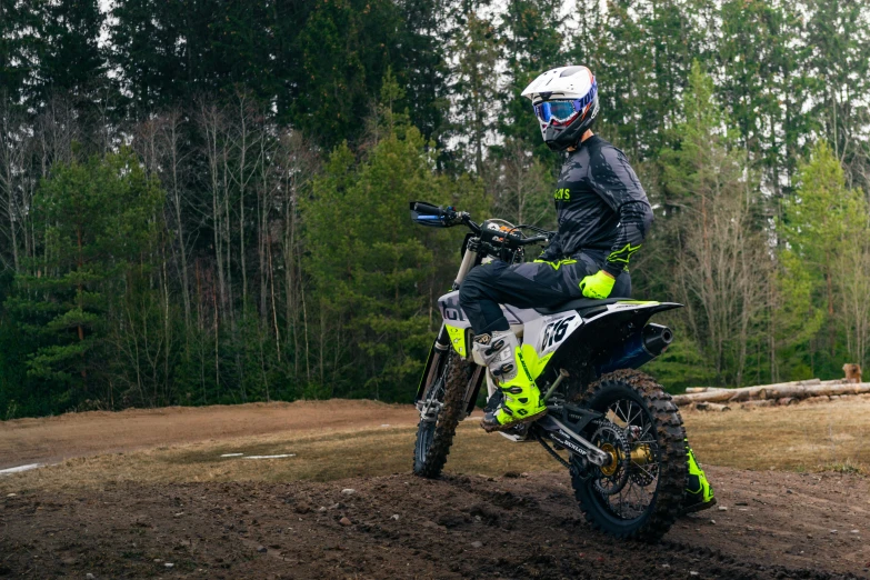 a man riding on the back of a yellow and black dirt bike