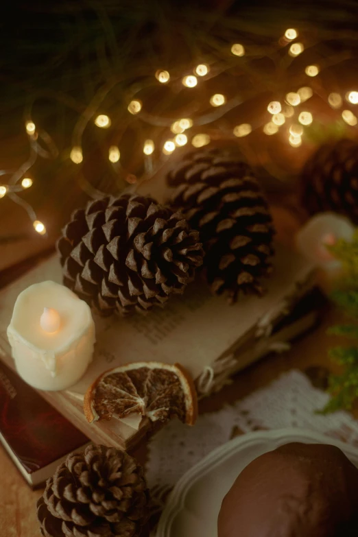 candles and pine cones sit on a table