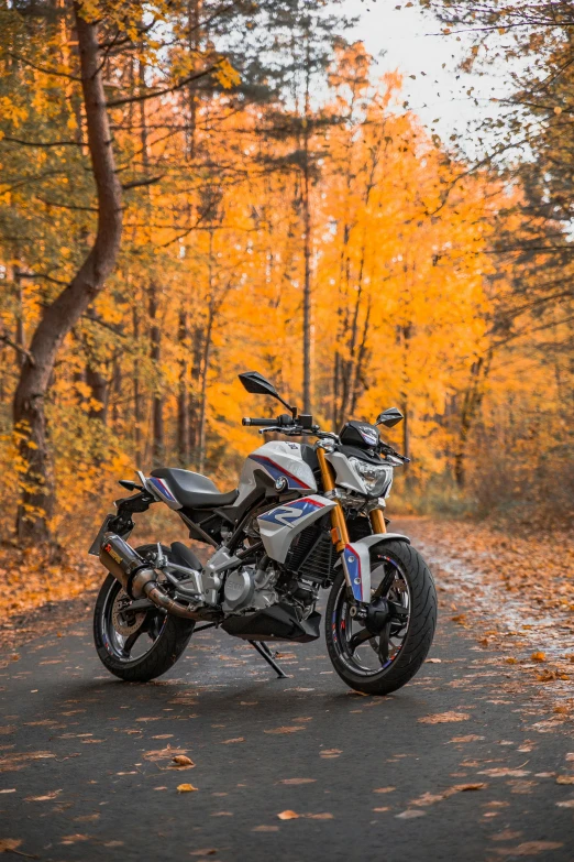 a motorcycle parked on the side of a road in front of trees