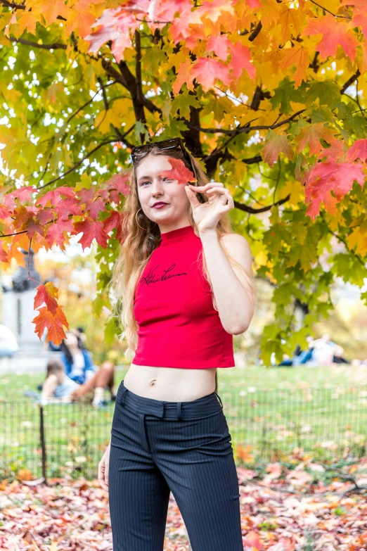 an image of a girl standing underneath trees in the fall